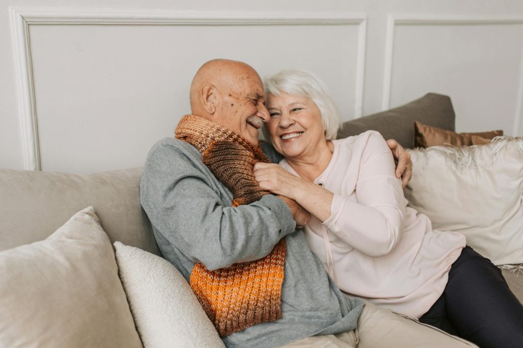 man in gray sweater hugging woman beside him